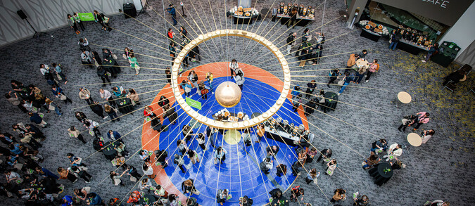 Principia pendulum above a busy convention lobby.